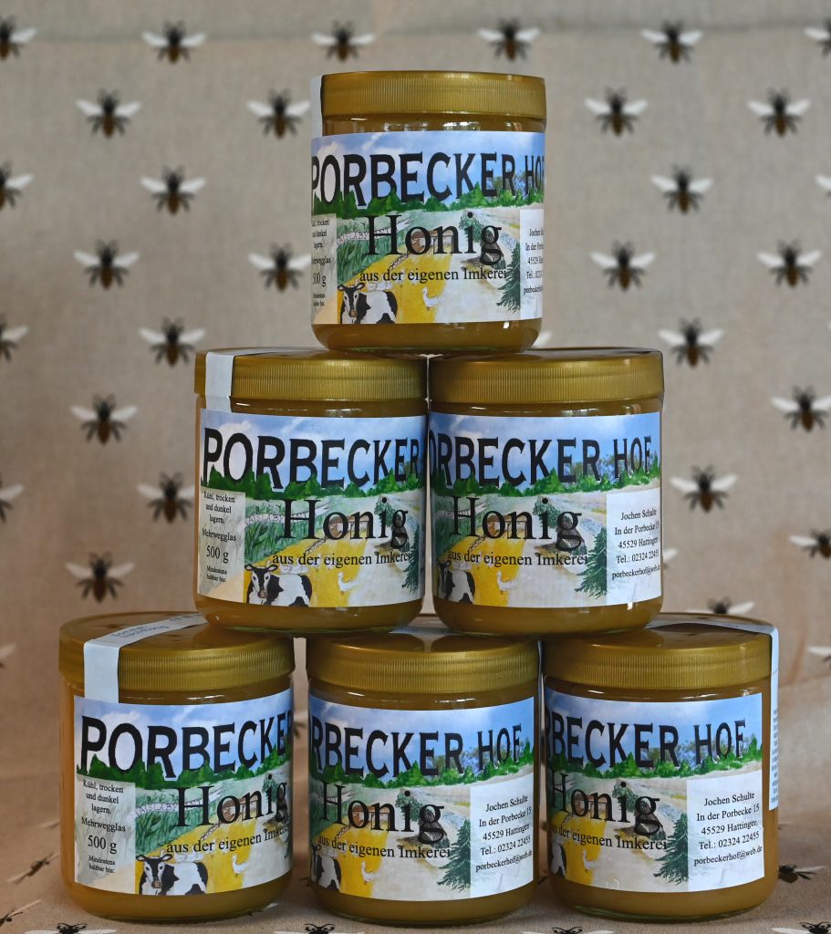 Sechs Gläser Honig von Porbeckerhof zu einer Pyramide gestapelt